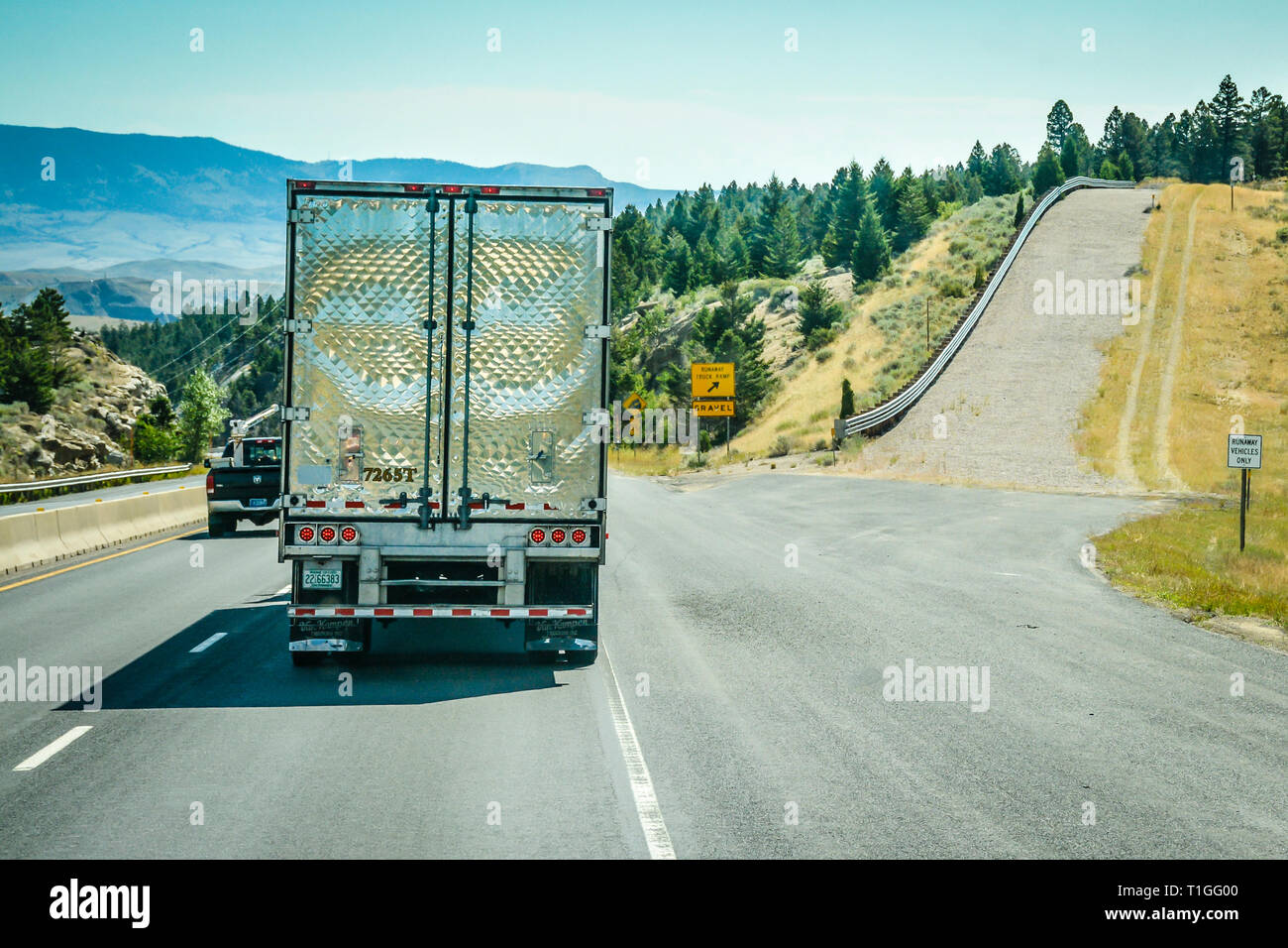 Ein Big Rig Truck bergab neben einem leeren runaway Lkw-Rampe auf einen steilen Hang von der Interstate I-90 Highway in Montana, USA Stockfoto