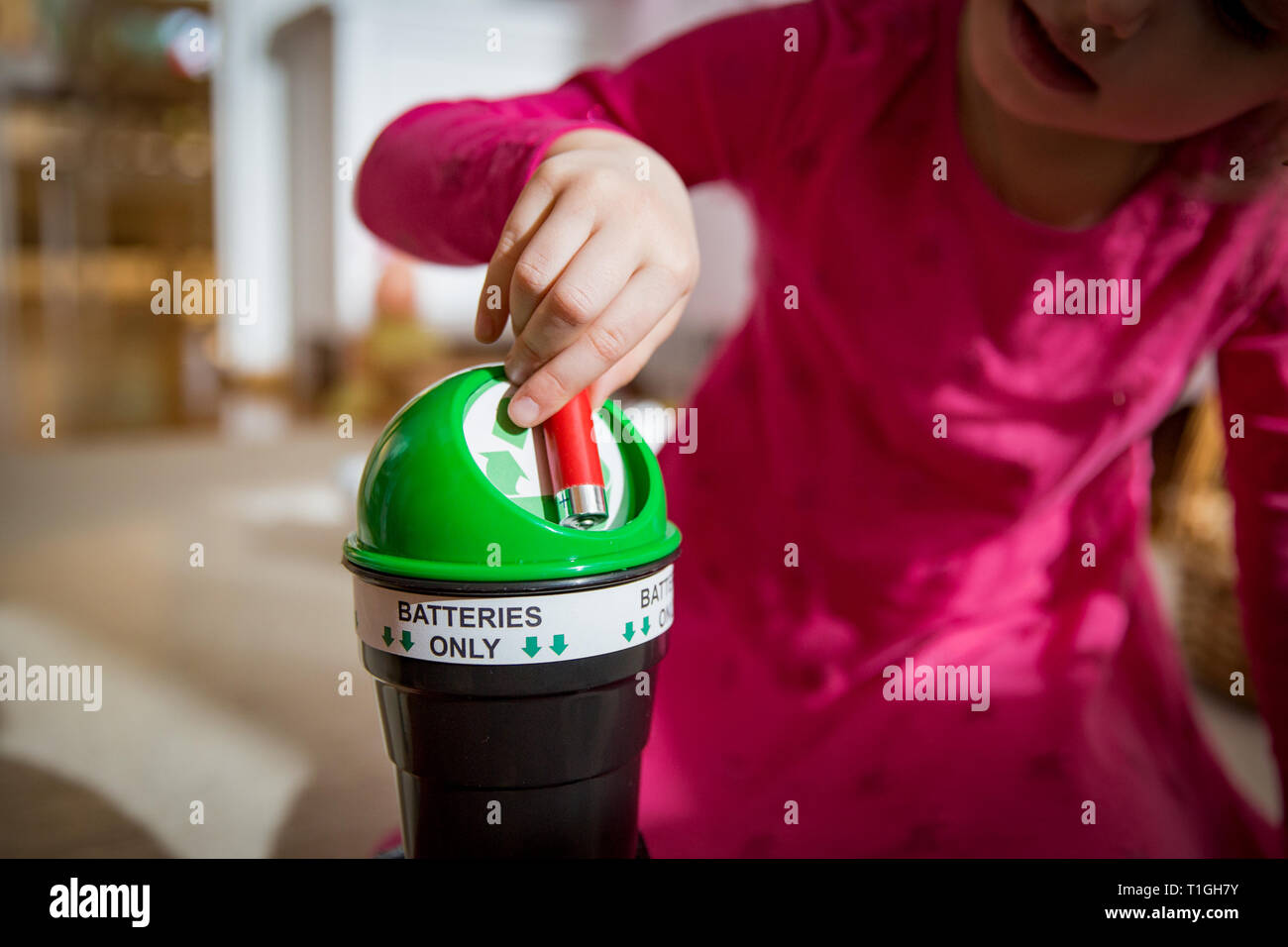 Kleines Mädchen, gebrauchte Batterien in Recycling Box zu Hause. Kind im Haus Zimmer Trennung von Abfällen. Batterien nur. Stockfoto