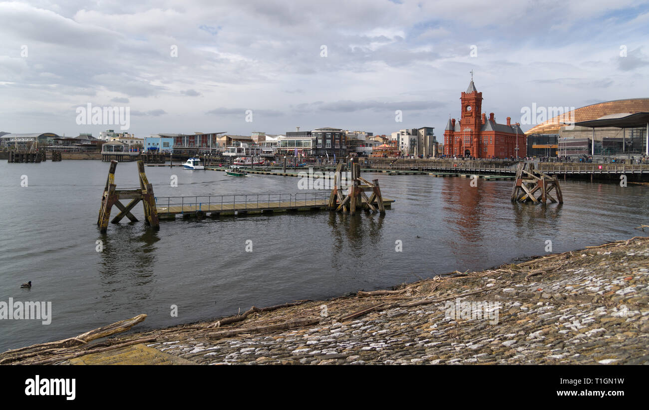 Überreste des alten Kais vor dem Mermaid Quay mit dem Pierhead-Gebäude und dem National Assembly-Gebäude im Hintergrund, Cardiff, Großbritannien Stockfoto