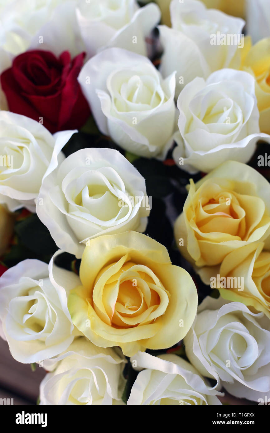 Blumenstrauß einschließlich weiße, gelbe und rote fake Rosen. Schöne Blumen ideal für Familienfeiern wie Hochzeiten und letzte für eine lange Zeit. Closeup Foto Stockfotografie