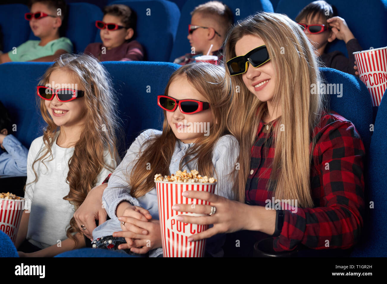 Kinder im Kino sitzen, tragen in der 3D-Brille, Premiere des neuen Film  oder Cartoon beobachten. Fröhliche Mutter und Tochter holding Popcornwanne,  genießen Film Stockfotografie - Alamy