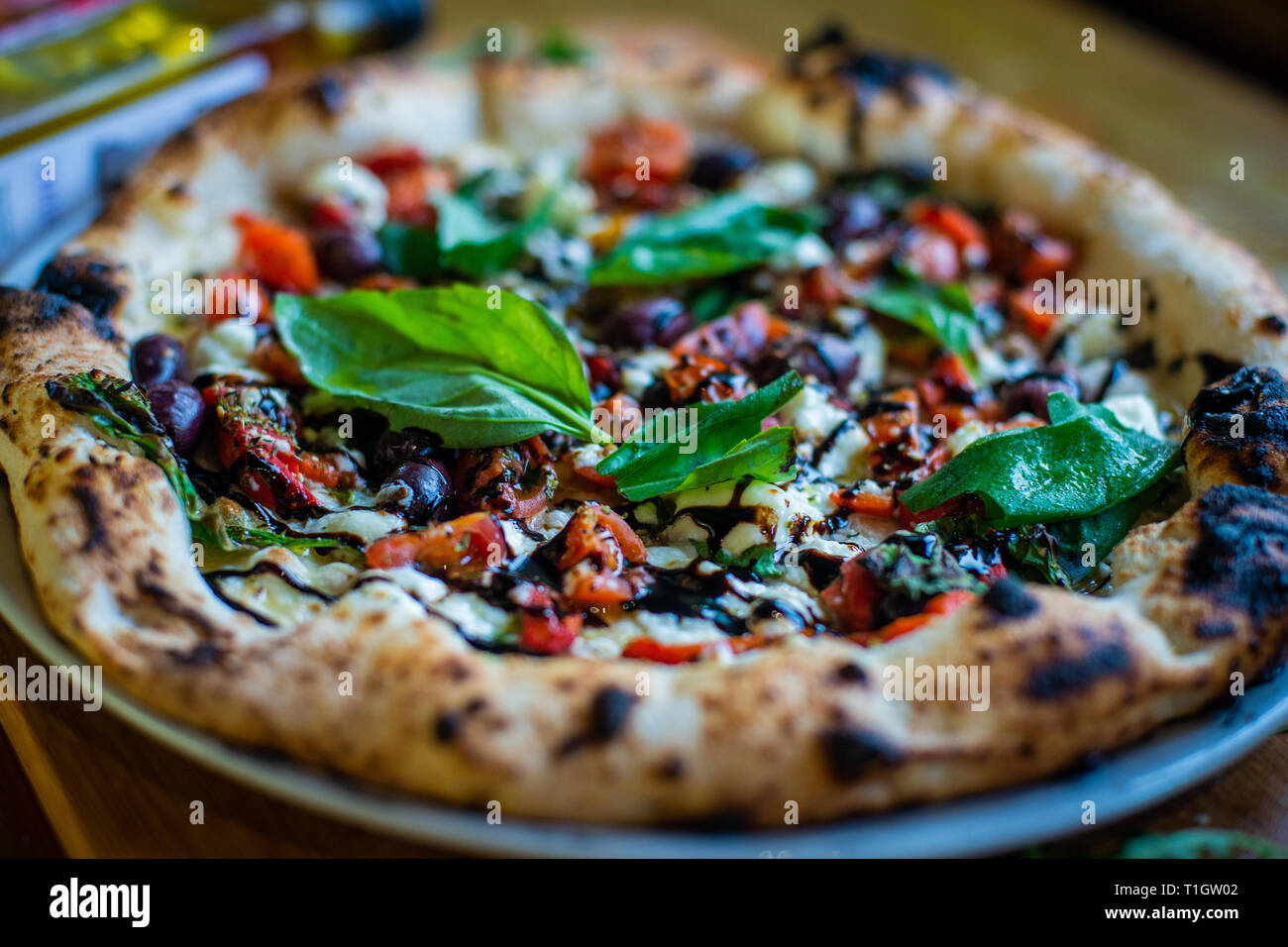 Authentische italienische neapolitanischen Stil Holzofen Pizza auf der Tabelle in einer Pizzeria Trattoria Restaurant Stockfoto