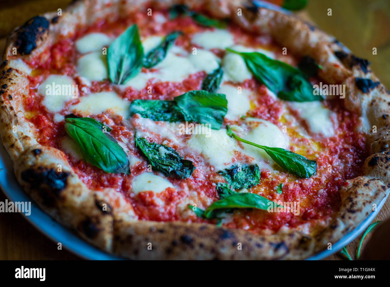Traditionelle authentische neapolitanische Stil Holzofen Pizza auf der Tabelle in einer Pizzeria Trattoria Restaurant Stockfoto