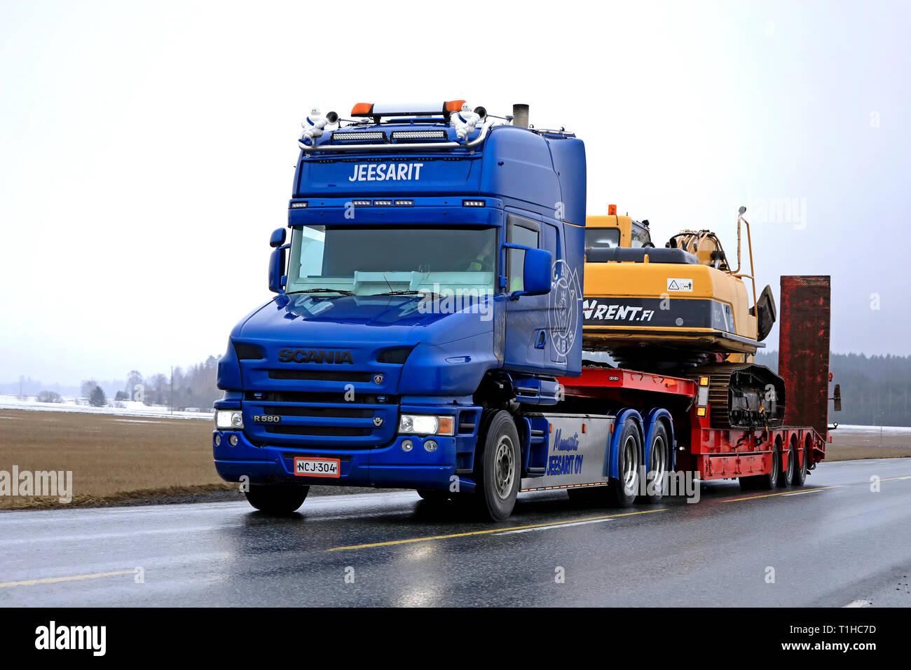 Jokioinen, Finnland - 23. März 2019: Blauer Scania R 580 konventionelle cab von Maansiirto Jeesarit Oy hols Raupenbagger am Anhänger entlang der Autobahn. Stockfoto