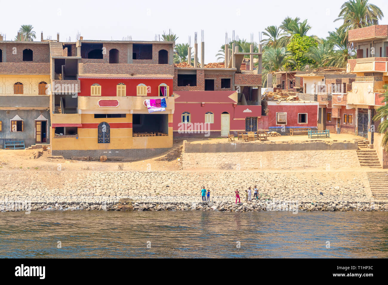 Assuan, Ägypten - September 13, 2018: Kinder winken zu Nil Kreuzfahrt Touristen neben dem Nil, im südlichen Ägypten Stockfoto