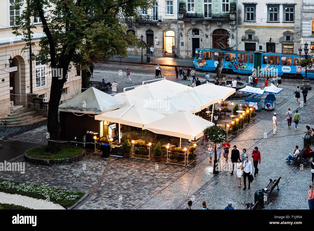Lemberg, Ukraine - 31. Juli 2018: Antenne Hohe Betrachtungswinkel der ukrainischen Stadt in der Altstadt Markt mit Cafe Restaurant, Springbrunnen in abends beleuchtet Stockfoto