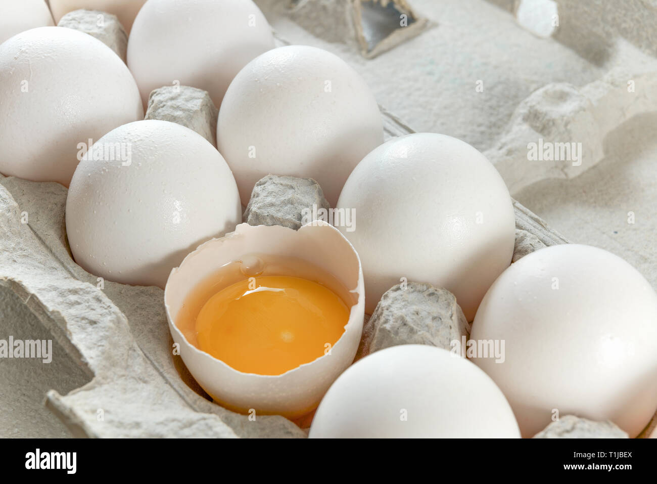 Frische weiße Eier im Karton auf Weiß, Nahaufnahme Stockfoto