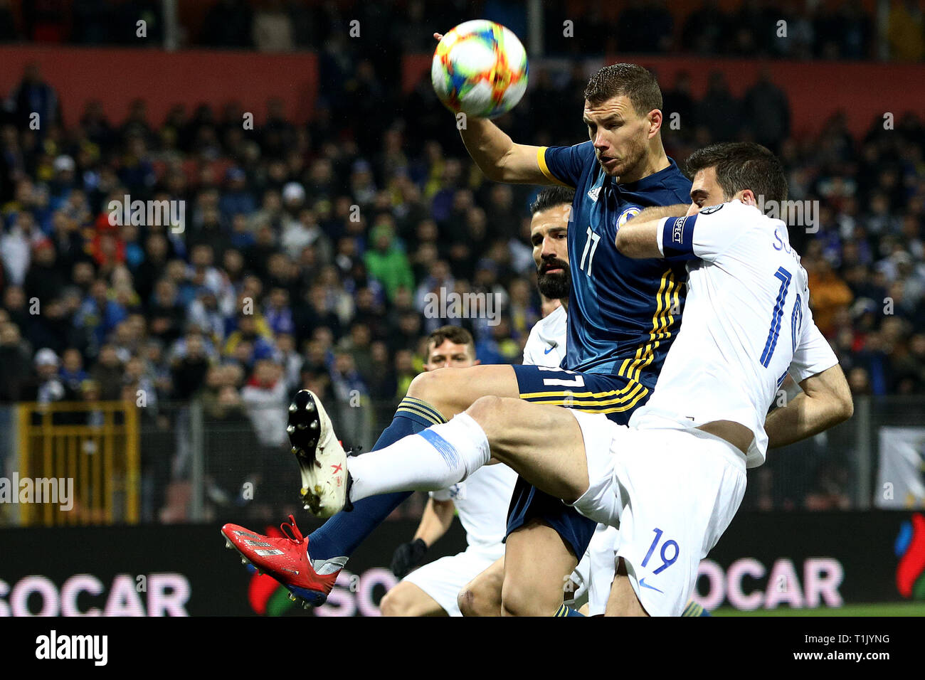 Zenica. 26 Mär, 2019. Edin Dzeko (oben) von Bosnien und Herzegowina konkurriert mit Sokratis Papastathopoulos von Griechenland während der UEFA EURO 2020 Qualifikation Gruppe J Match zwischen Bosnien und Herzegowina (BiH) und Griechenland in Zenica, Bosnien und Herzegowina am 26. März 2019. Das Spiel endete mit einem 2:2-Unentschieden. Credit: Nedim Grabovica/Xinhua/Alamy leben Nachrichten Stockfoto