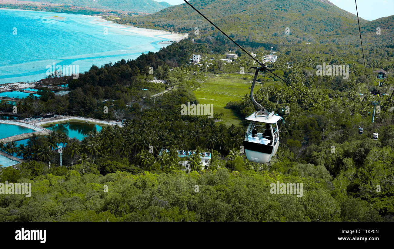 Seilbahn mit Touristen innerhalb und vor dem Hintergrund der Hainan Provinz, China Stockfoto