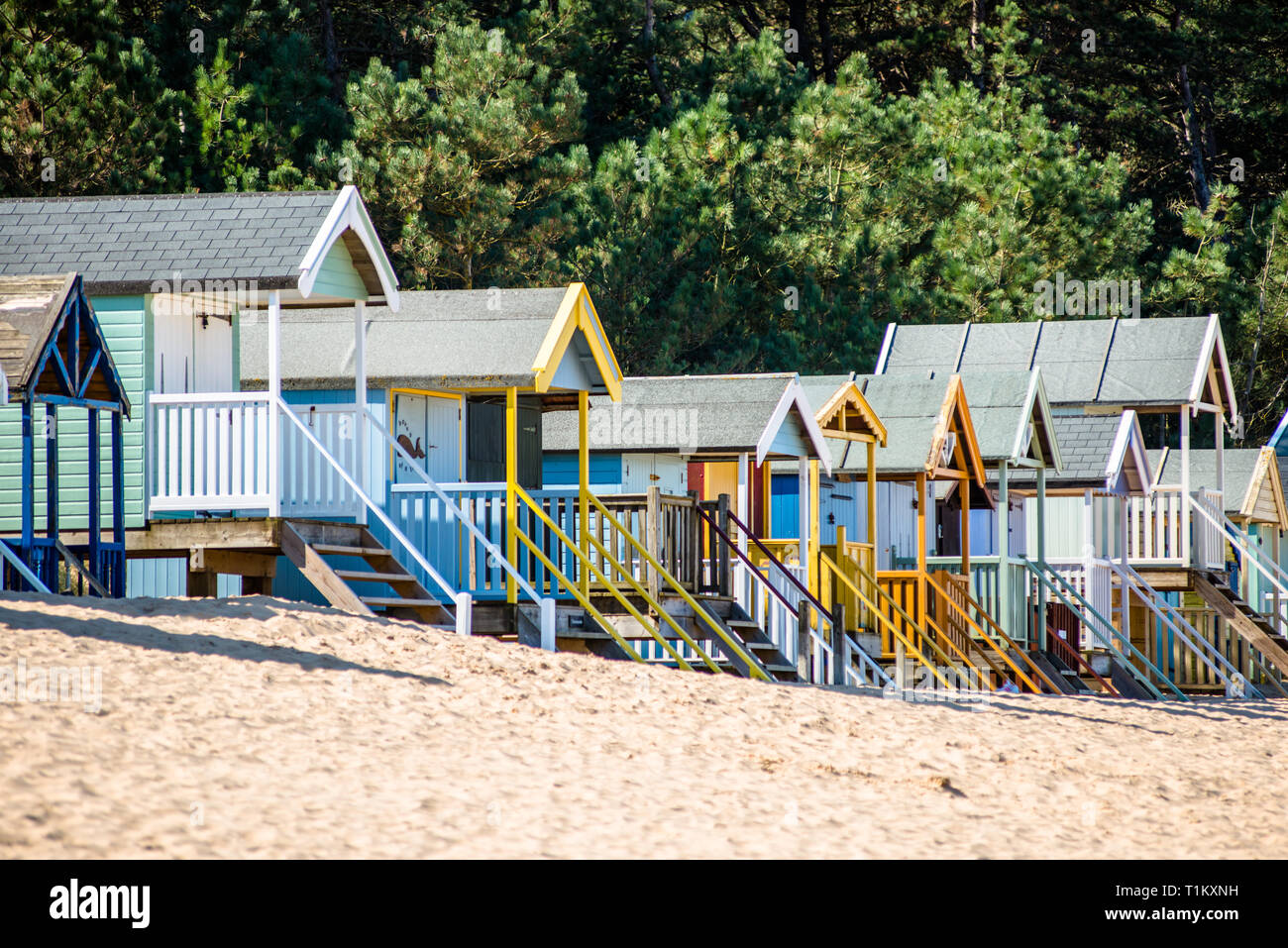 Bunten Badekabinen am Strand an der Brunnen Brunnen neben dem Meer auf North Norfolk Coast, East Anglia, England, UK. Stockfoto