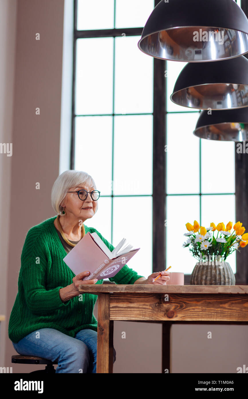 Charmante Oma reagieren auf jemanden Buch in der Hand halten Stockfoto