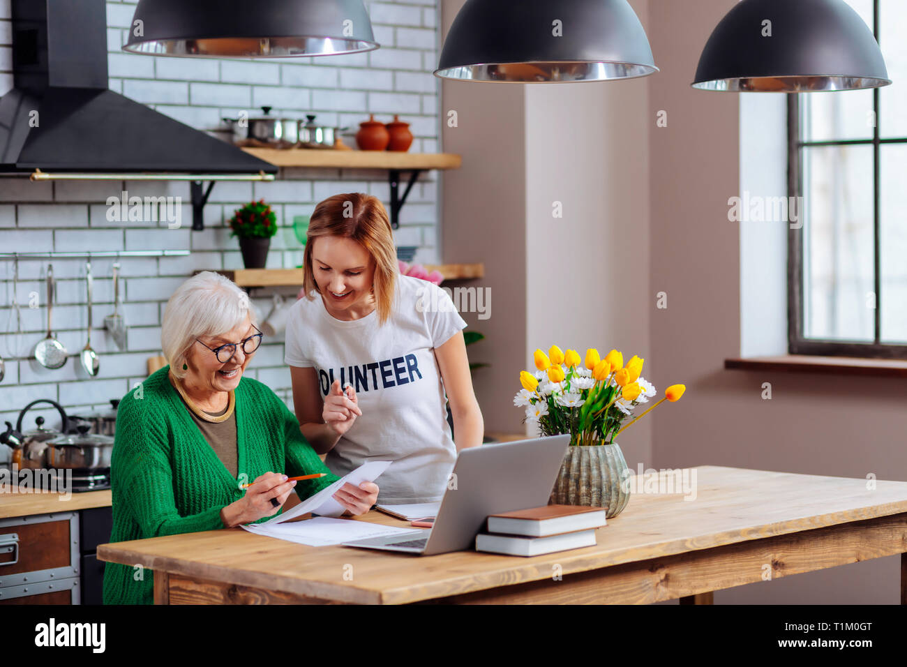 Gut - ansprechende Assistant hilft im Alter von Granny Dokumente zu unterzeichnen Stockfoto