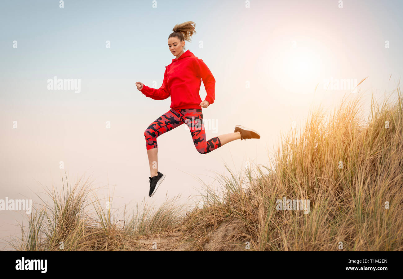 Frau durch Sanddünen laufen Stockfoto