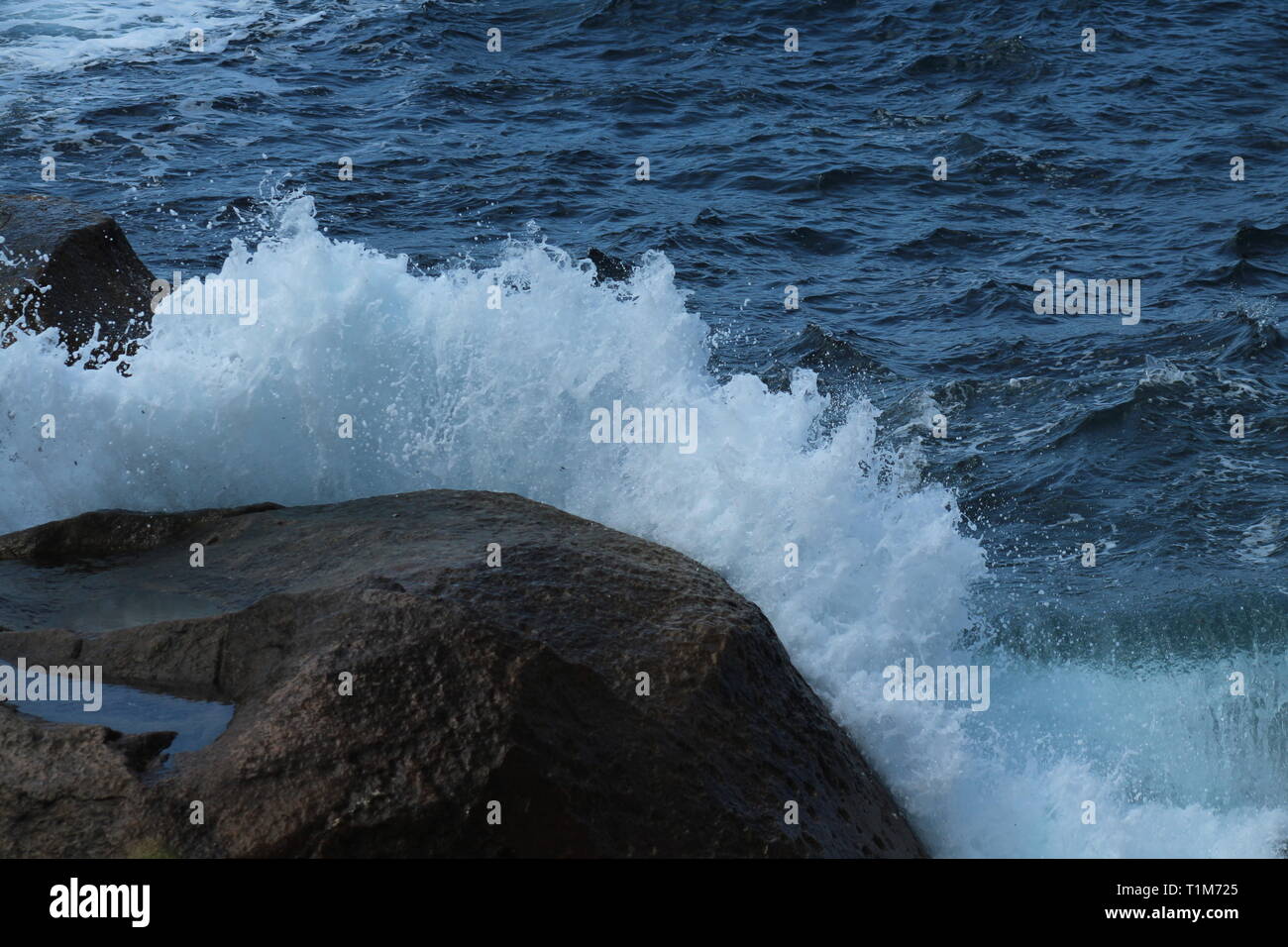 Wellen gegen Felsen und fliegen in die Luft an der Küste in einem kleinen Dorf in Korsika ist eine Insel, die nur aus Frankreich gefunden. Stockfoto