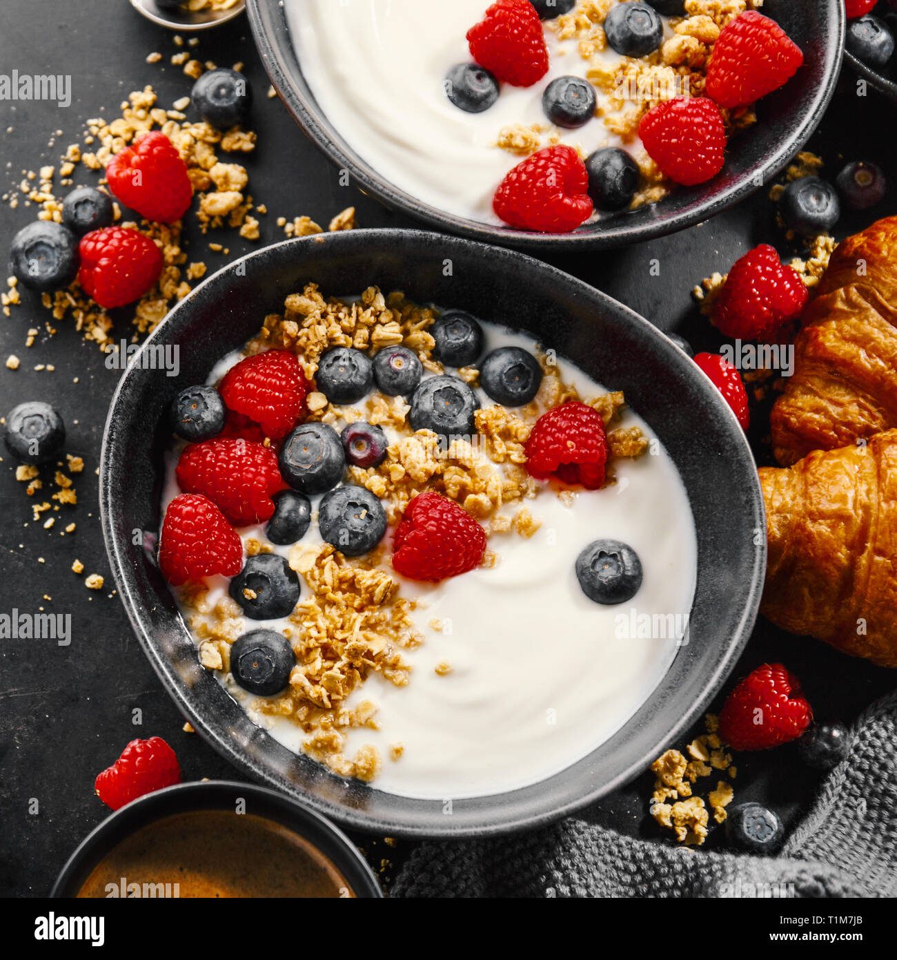 Lecker frisches Frühstück mit Joghurt, Müsli und Obst in der Schüssel  serviert. Der dunkle Hintergrund. Nahaufnahme. Platz Stockfotografie - Alamy