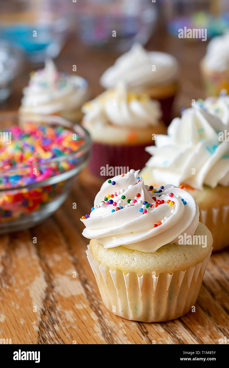 In der Nähe von Mini eingerichtet mini Cupcake mit Frühling und Ostern Streuseln. Zusätzliche besprüht und Törtchen unscharf im Hintergrund. Stockfoto