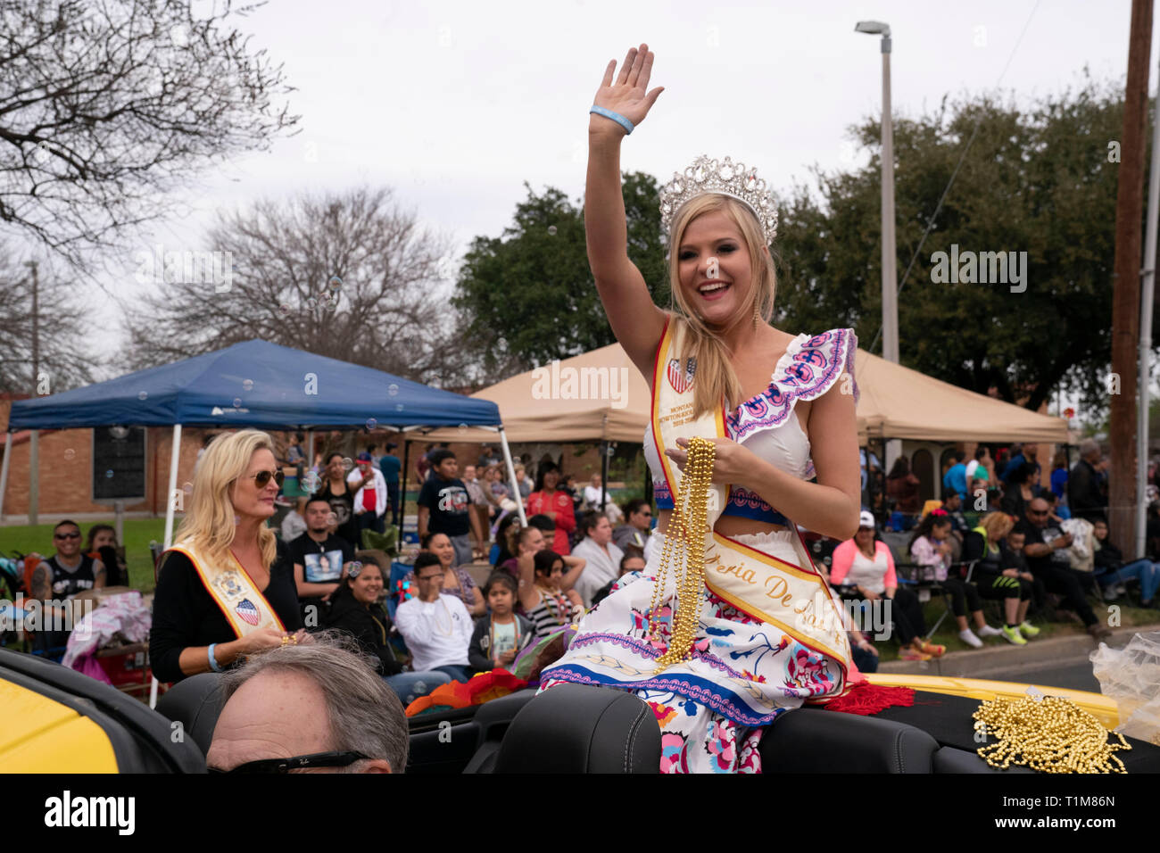 Junge Frau Krone tragen sitzt auf der Rückseite des Cabrio und Wellen zu Masse während der jährlichen Washington' Geburtstagsfeier Parade in Laredo, TX USA Stockfoto