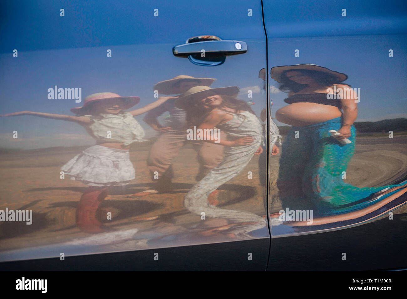 Reflexion der Schwangeren und der Familie auf der sonnigen Autotür Stockfoto
