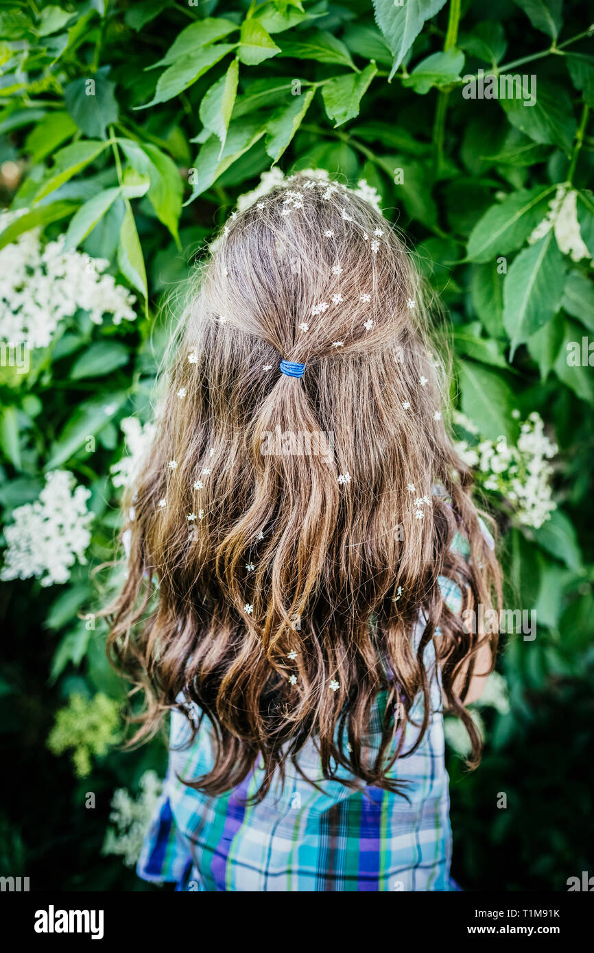 Mädchen mit Blumen im Haar an blühende Strauch Stockfoto
