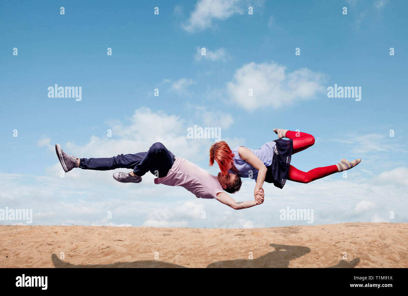Moderne Aerialist-Tänzer treten auf, fliegen über den Strand Stockfoto