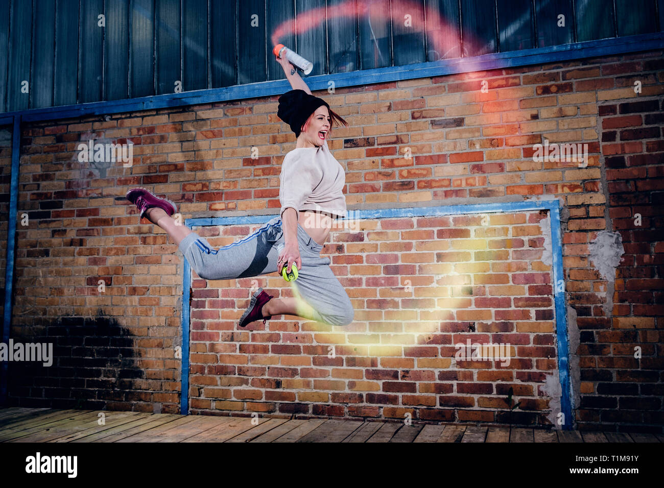 Weibliche moderne Tänzerin, die mit Spraydosen auftrat Stockfoto