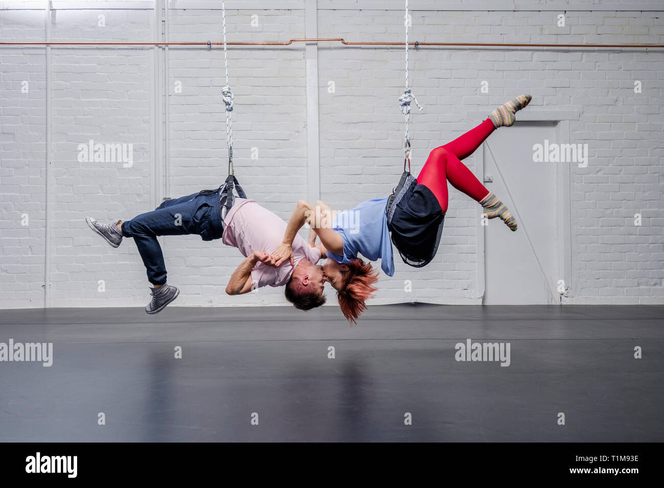 Moderne aerialistische Tänzer treten auf, hängen kopfüber und küssen Stockfoto