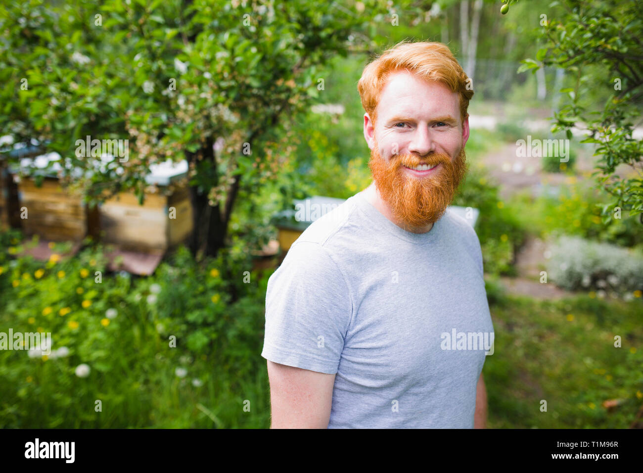 Porträt Lächeln, selbstbewussten Mann mit roten Haaren im Garten Stockfoto