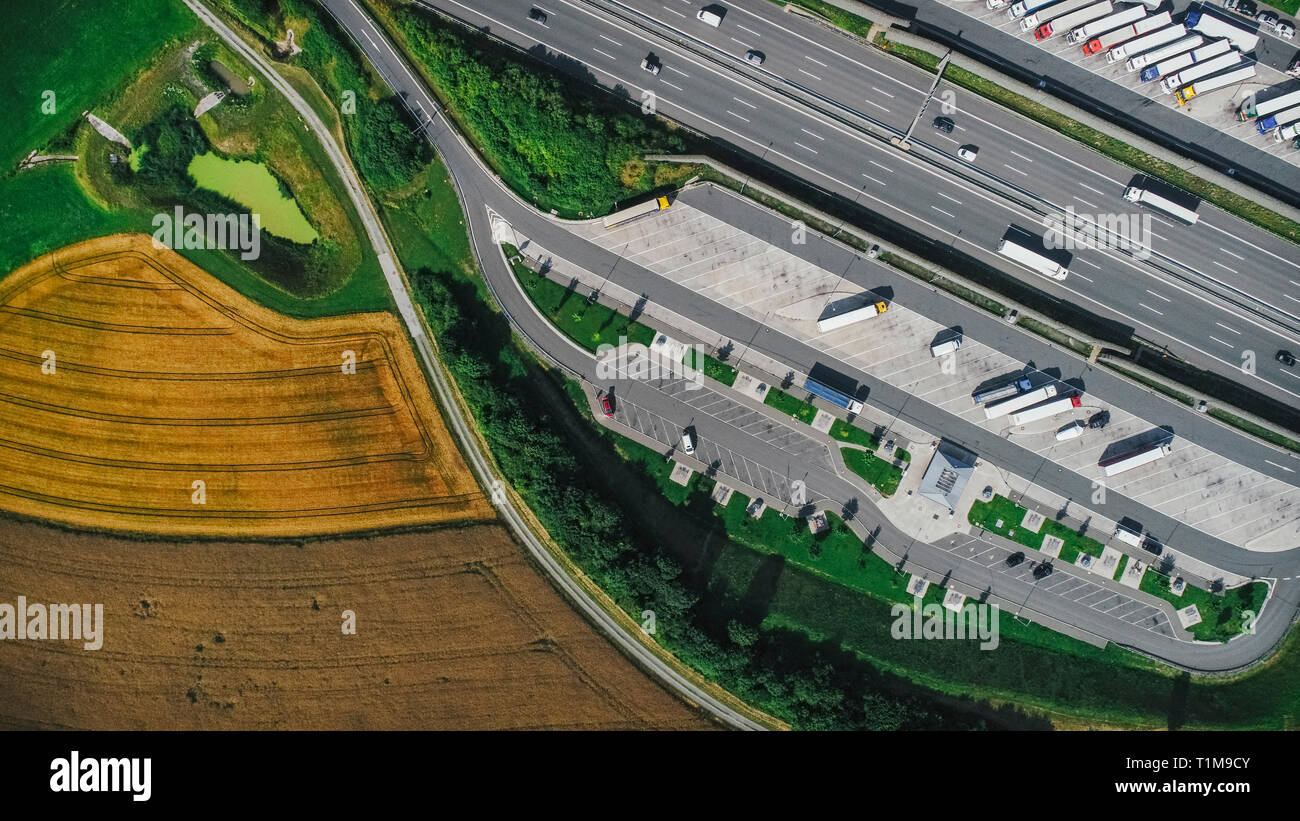 Drone Sicht semi-Lkw Truck Stop zwischen Landstraße und Ackerland, Bayern geparkt, Deutschland Stockfoto