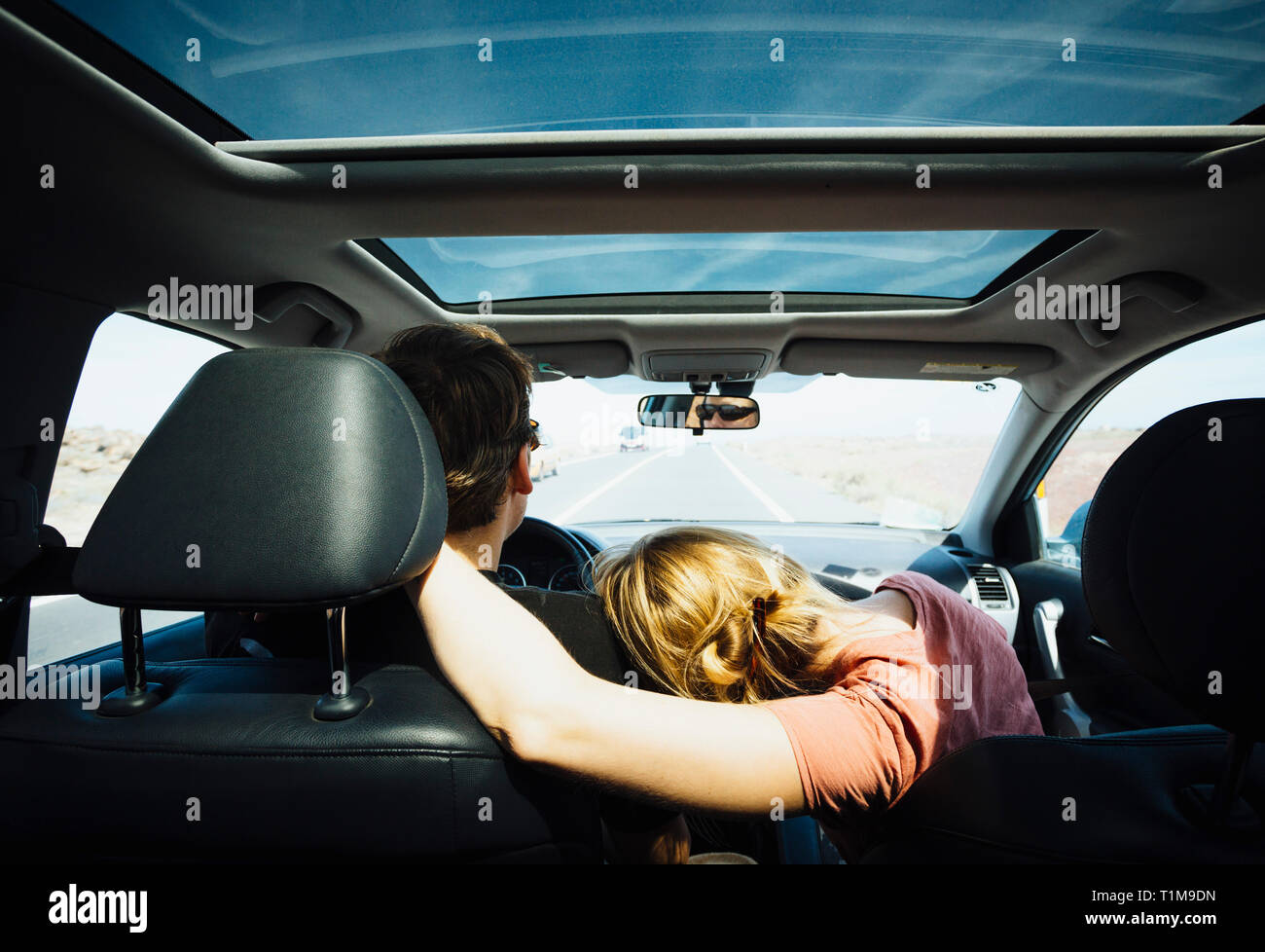 Liebevolles Paar Reiten im sonnigen Auto Stockfoto