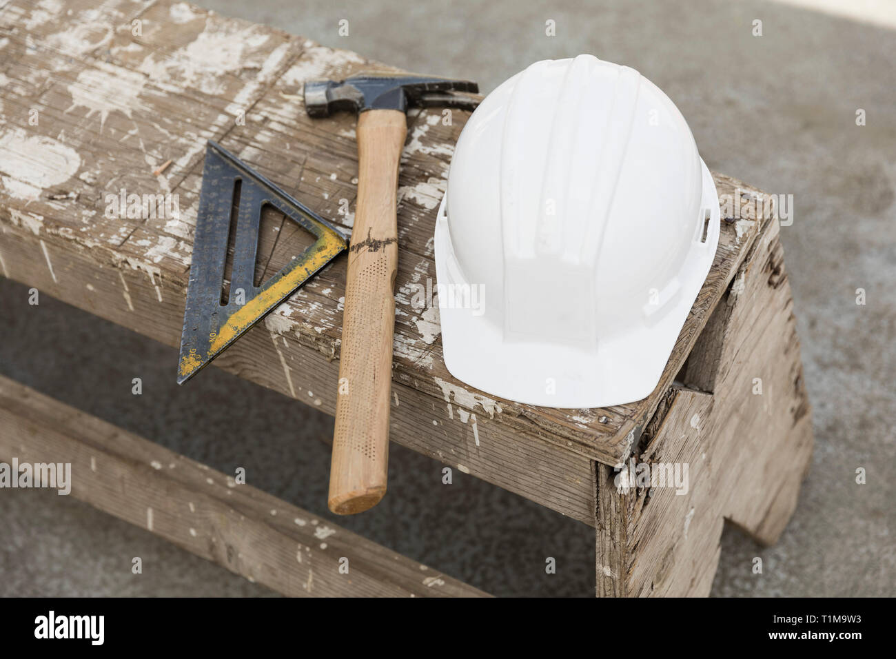 Helm, Hammer und Lineal auf der Werkbank Stockfoto