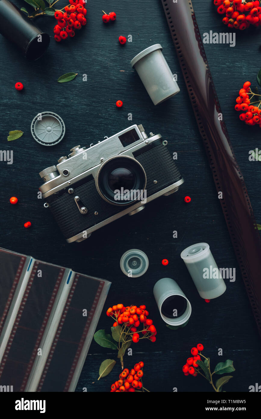 Flach hipster style Old vintage Fotografie Kamera auf dunklem Hintergrund mit Blumenschmuck Stockfoto