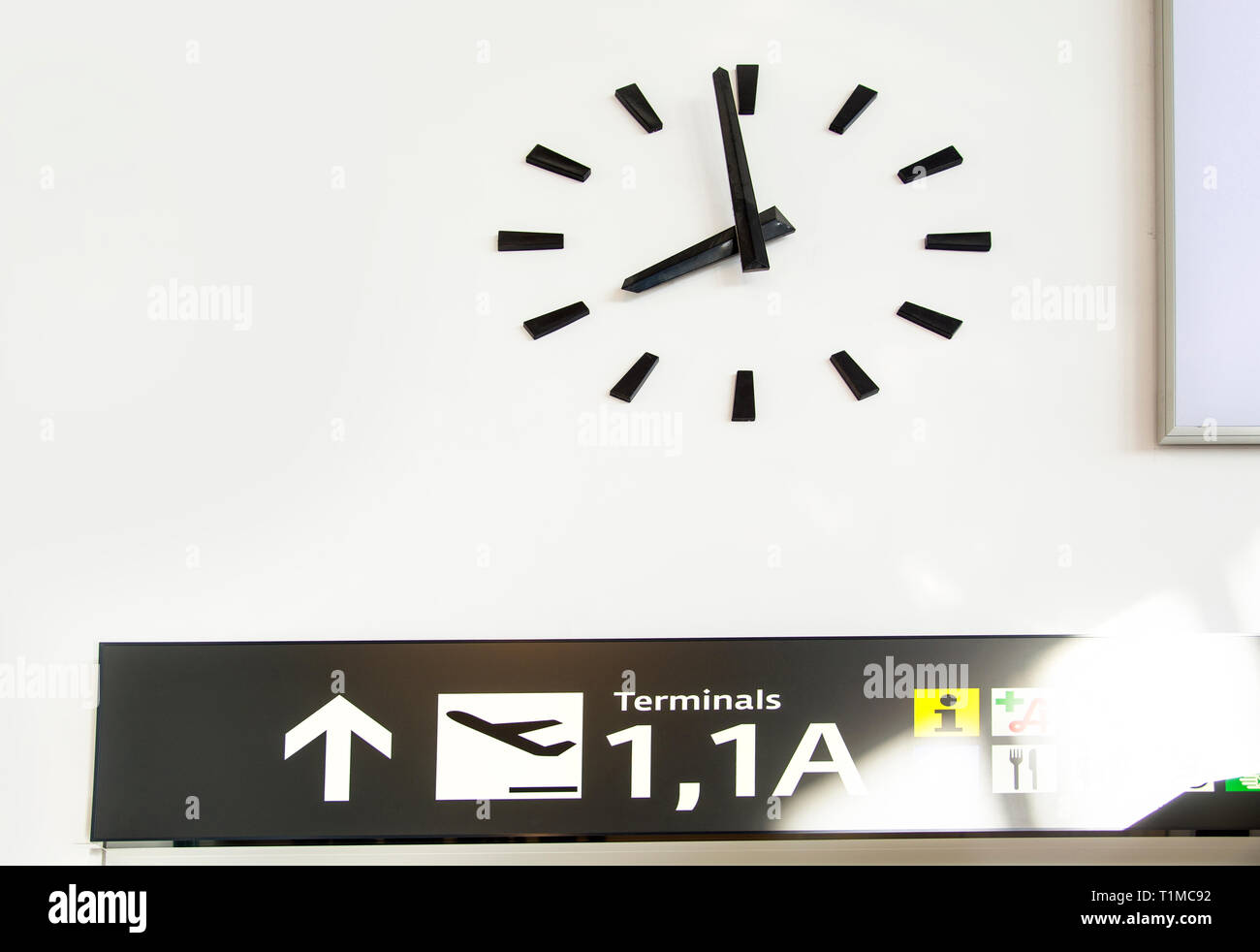 Wanduhr auf einem Flughafen mit Navigation Panel Stockfoto
