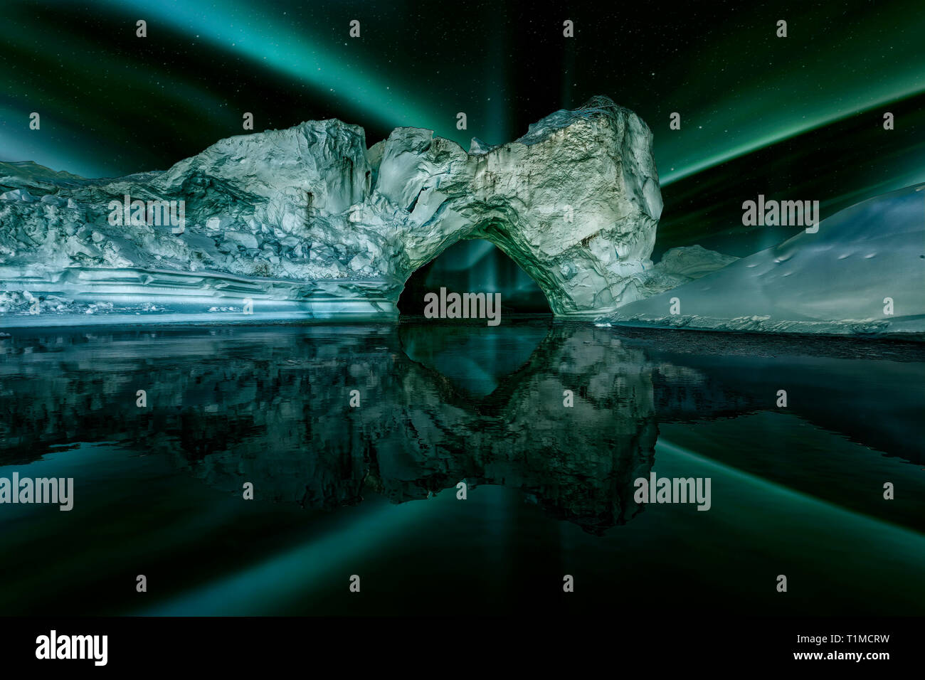 Eisberg floating in Grönland Fjord bei Nacht mit grünem northern lights. Stockfoto