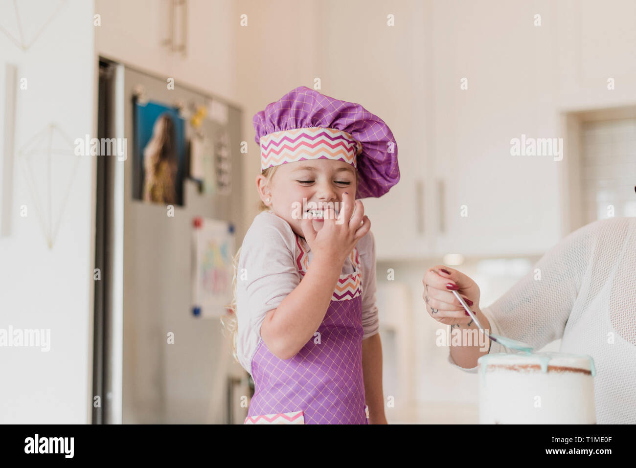 Glücklich, süße Mädchen in chefÕs hat Backen in der Küche Stockfoto