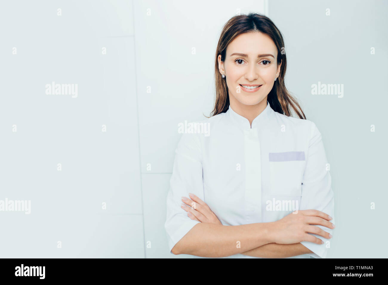 Porträt Lächeln auf den Arzt, der mit den Armen an der Klinik gekreuzt Stockfoto