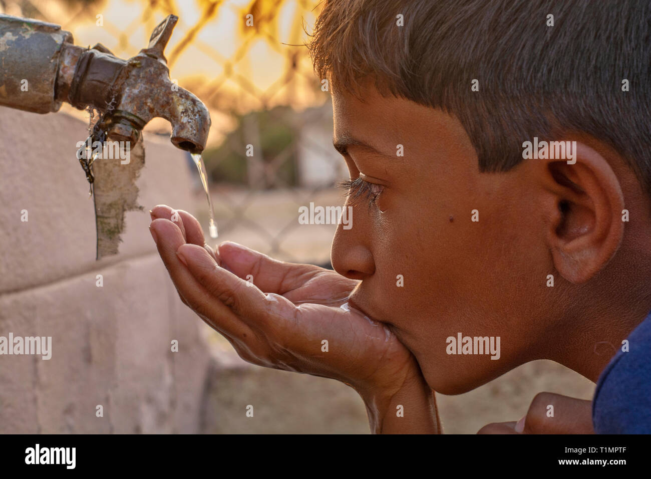 Maski, Karnataka, Indien - 26, März 2019: Nahaufnahme von Kind Trinkwasser direkt aus Corporation Wasser in Indien tippen. Stockfoto