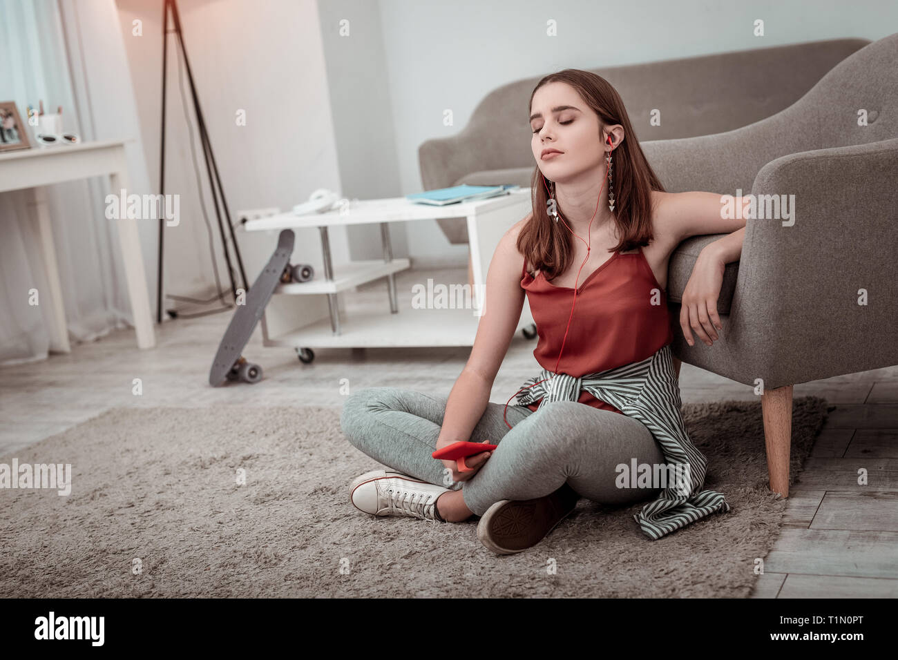 Junge Frau, die zu Hause Musik hören Stockfoto