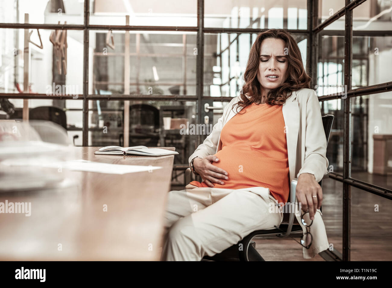 Sick erwartet Frau ihren Bauch während der schmerzhaften Zeit Stockfoto