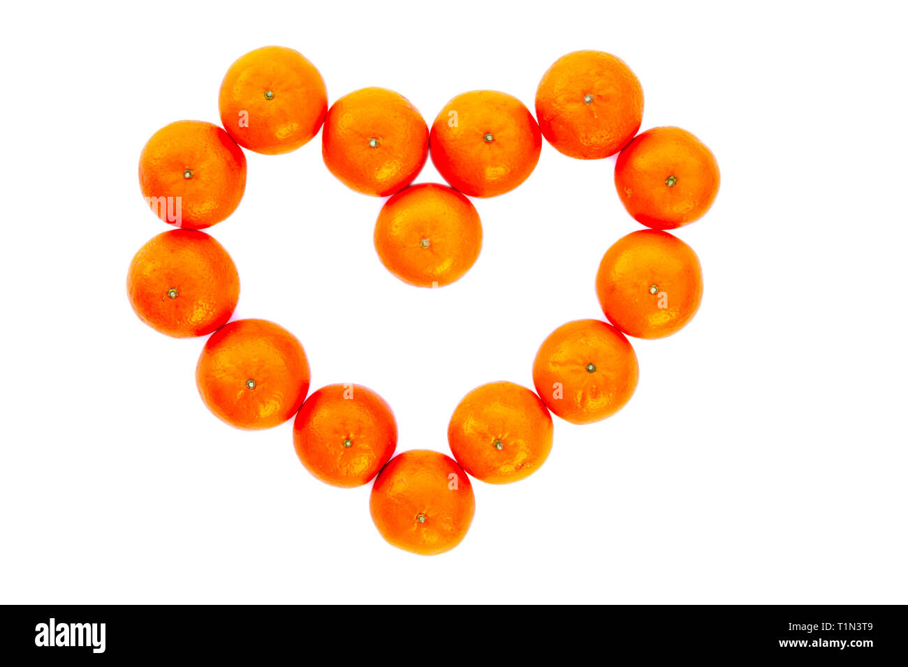 Herzform mit Mandarinen auf weißem Hintergrund gelöst. Valentinstag Symbol mit Mandarinen. Liebe Stockfoto