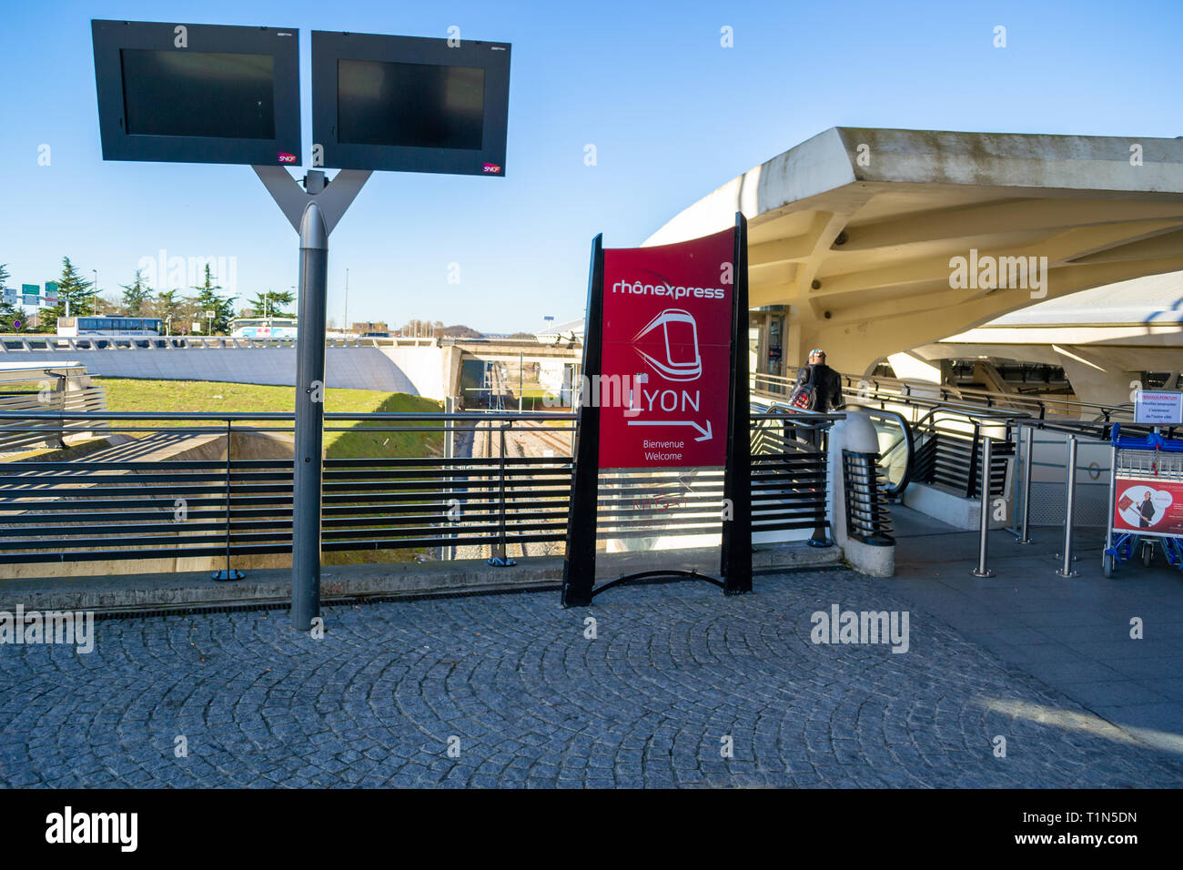 Lyon, Frankreich - 16. März 2019: Zeichen für die Rhonexpress Straßenbahn-verbindung Lyon Saint-Exupery Flughafen. Mann mit der Rolltreppe Stockfoto