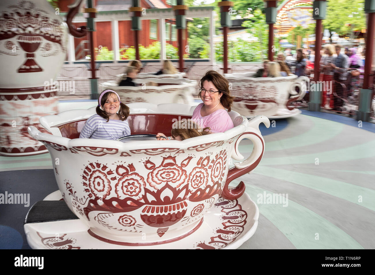 Glückliche Mutter und zwei Mädchen Spaß in einer Spinnerei Tee cup Fahrt in den Vergnügungspark Gröna Lund, Djurgården, Stockholm, Skandinavien Stockfoto