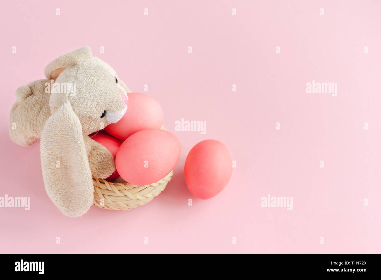 Flauschige Ostern Hase mit leuchtend rosa colorsd Eier in den Korb auf Pastell rosa Hintergrund. Kopieren Sie Platz. Stockfoto