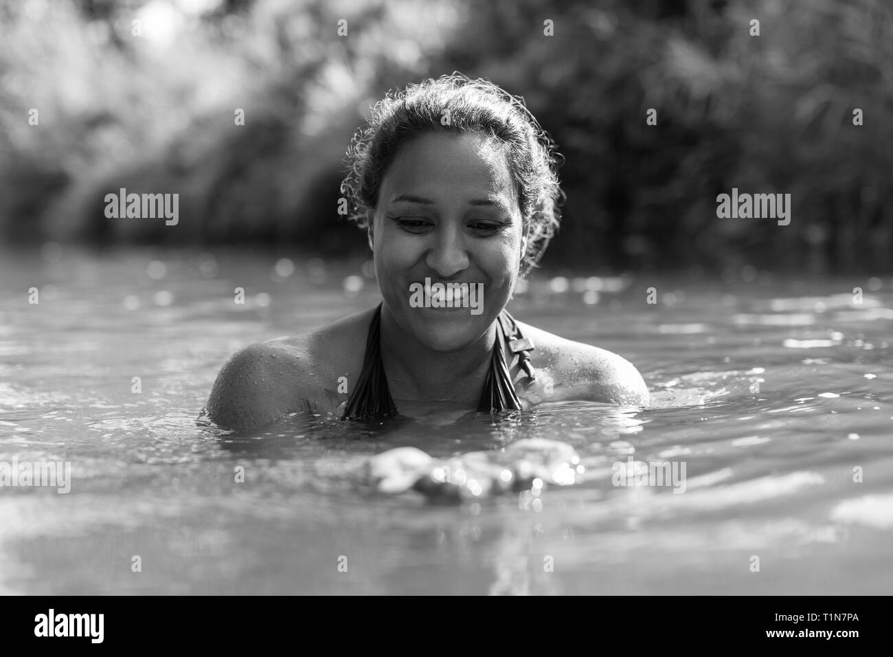 Glückliche Frau schwimmen im sonnigen Fluss Stockfoto
