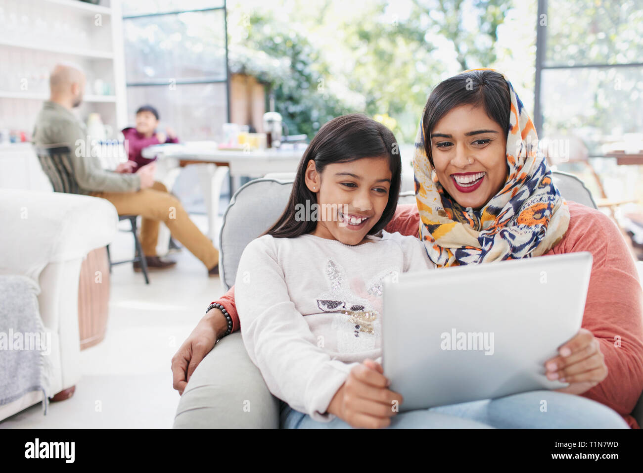 Glückliche Mutter im hijab und Verwendung digitaler tablet Tochter Stockfoto