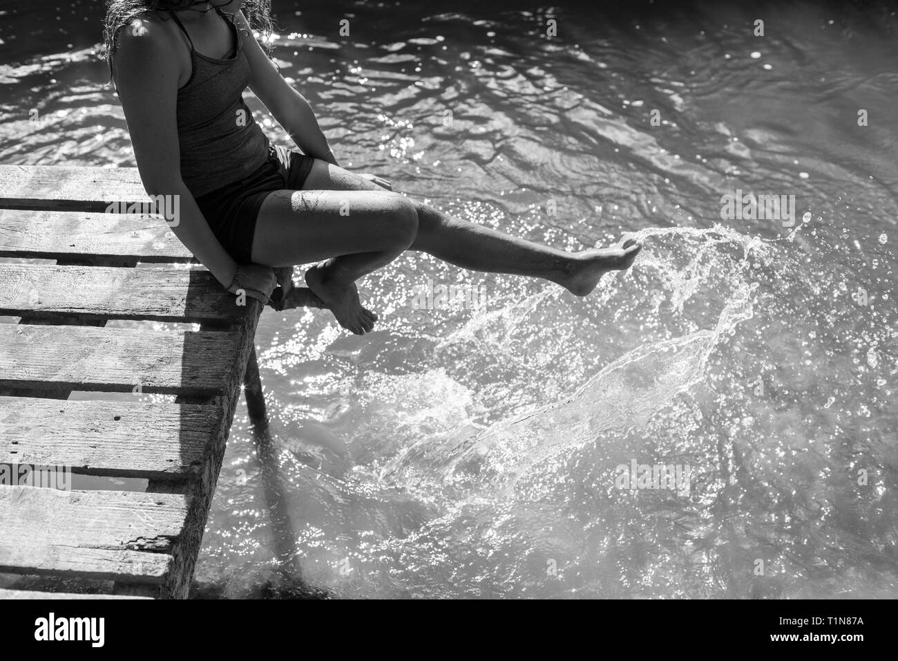 Verspielte Mädchen Spritzer Füße im sonnigen Fluss Stockfoto