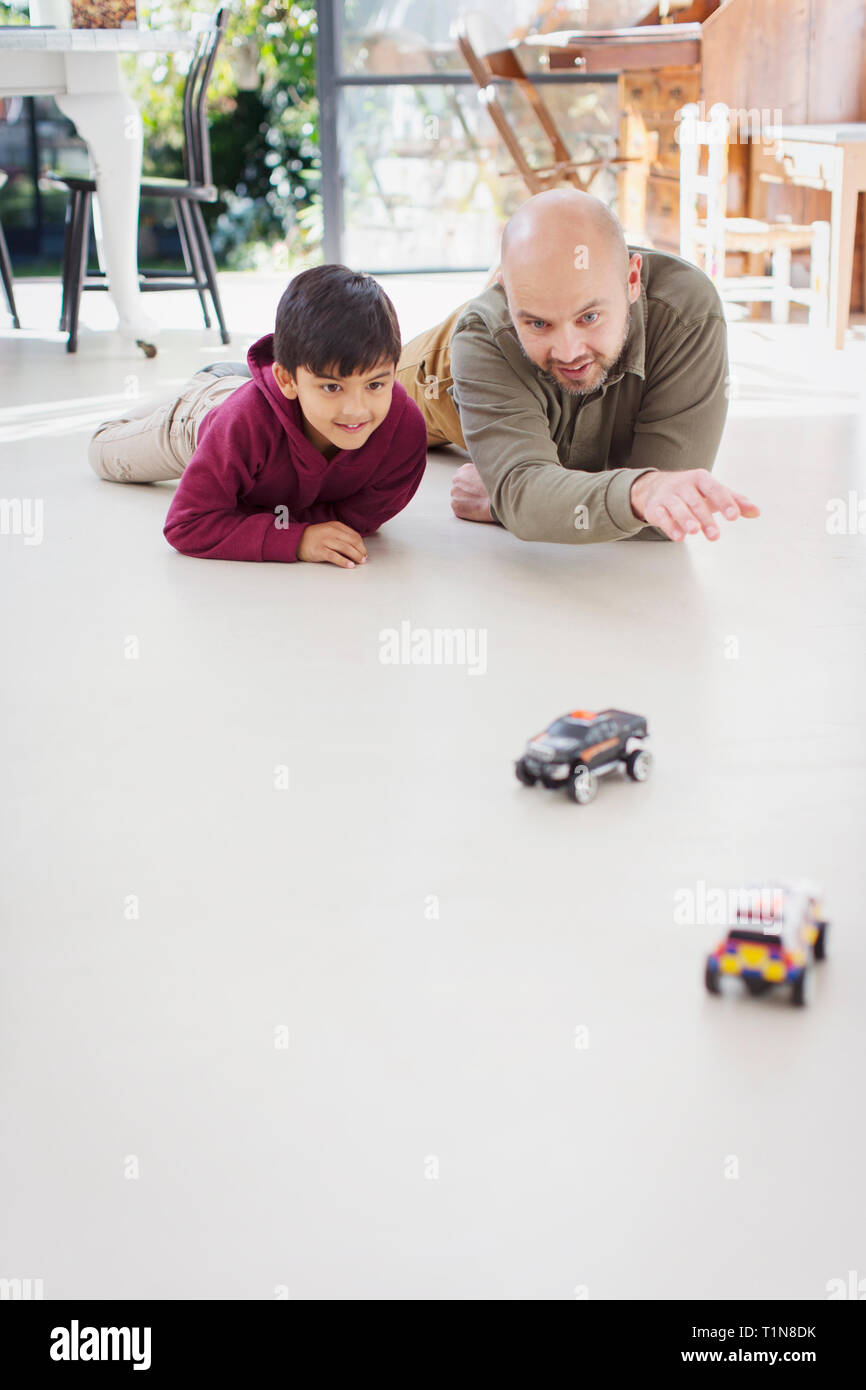Vater und Sohn spielen mit Spielzeug Autos auf dem Boden Stockfoto