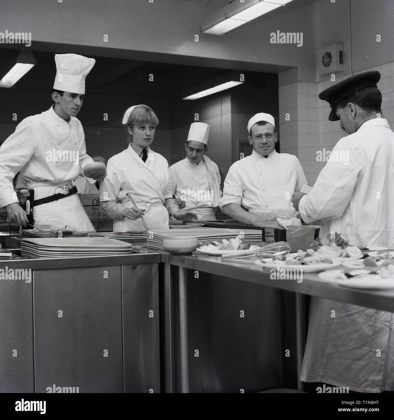 1967, weiß beschichteten Auszubildende Köche unter Aufsicht Vorbereiten der Nahrung auf ein RAF Base, England, UK. Stockfoto