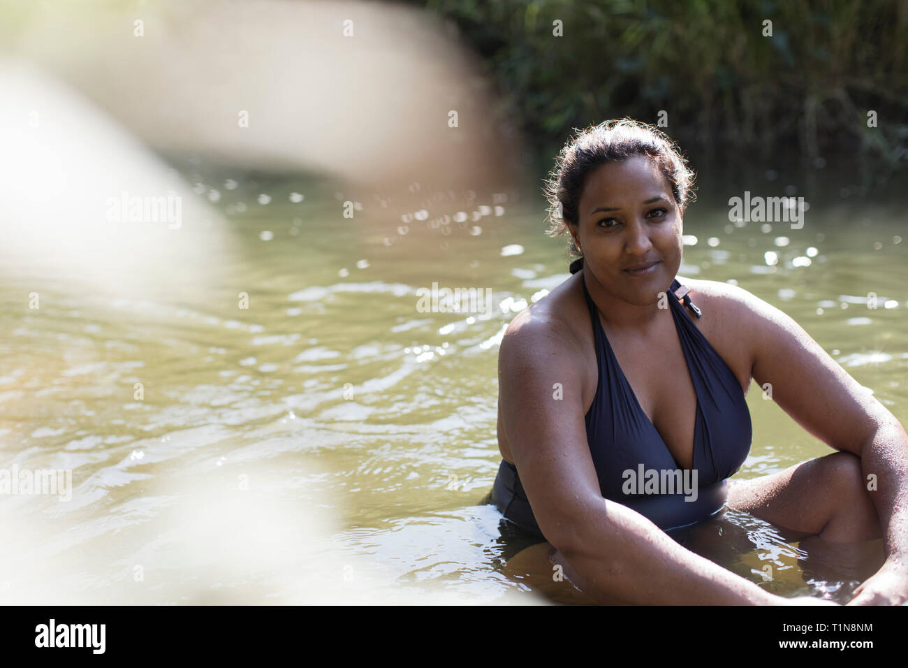 Portrait lächelnde Frau Entspannung im sonnigen Fluss Stockfoto