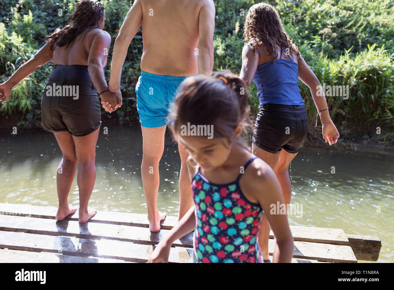 Familie spielen, springen Dock in sonnigen Fluss Stockfoto