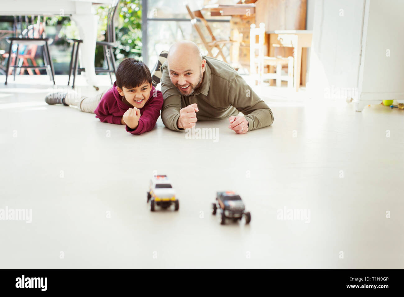 Vater und Sohn spielen mit Spielzeug Autos auf dem Boden Stockfoto